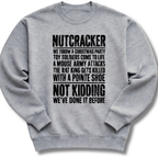 A light gray crewneck sweatshirt with black distressed text on the front that reads 'NUTCRACKER WE THROW A CHRISTMAS PARTY TOY SOLDIERS COME TO LIFE A MOUSE ARMY ATTACKS THE RAT KING GETS KILLED WITH A POINTE SHOE NOT KIDDING WE'VE DONE IT BEFORE.'.