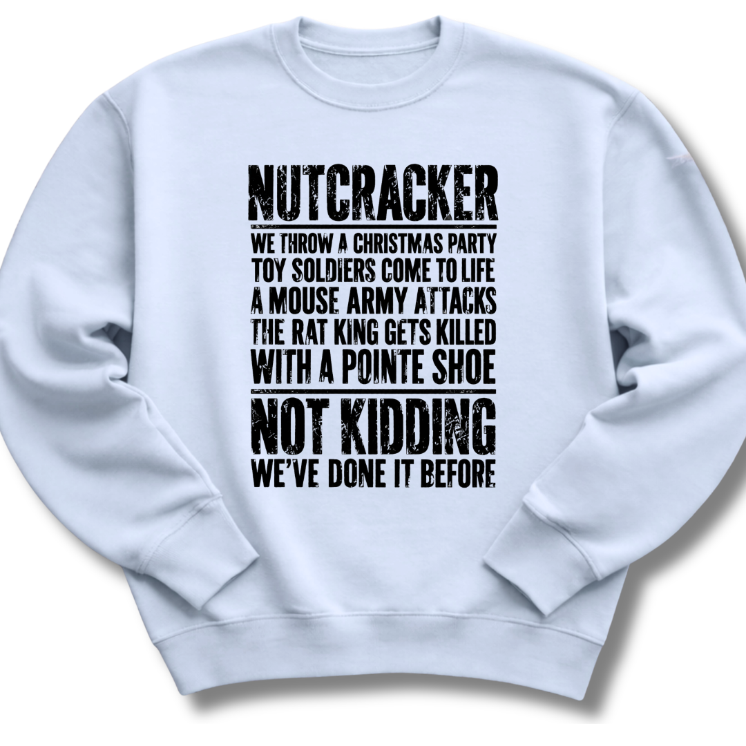 A light blue crewneck sweatshirt with black distressed text on the front that reads 'NUTCRACKER WE THROW A CHRISTMAS PARTY TOY SOLDIERS COME TO LIFE A MOUSE ARMY ATTACKS THE RAT KING GETS KILLED WITH A POINTE SHOE NOT KIDDING WE'VE DONE IT BEFORE.'.