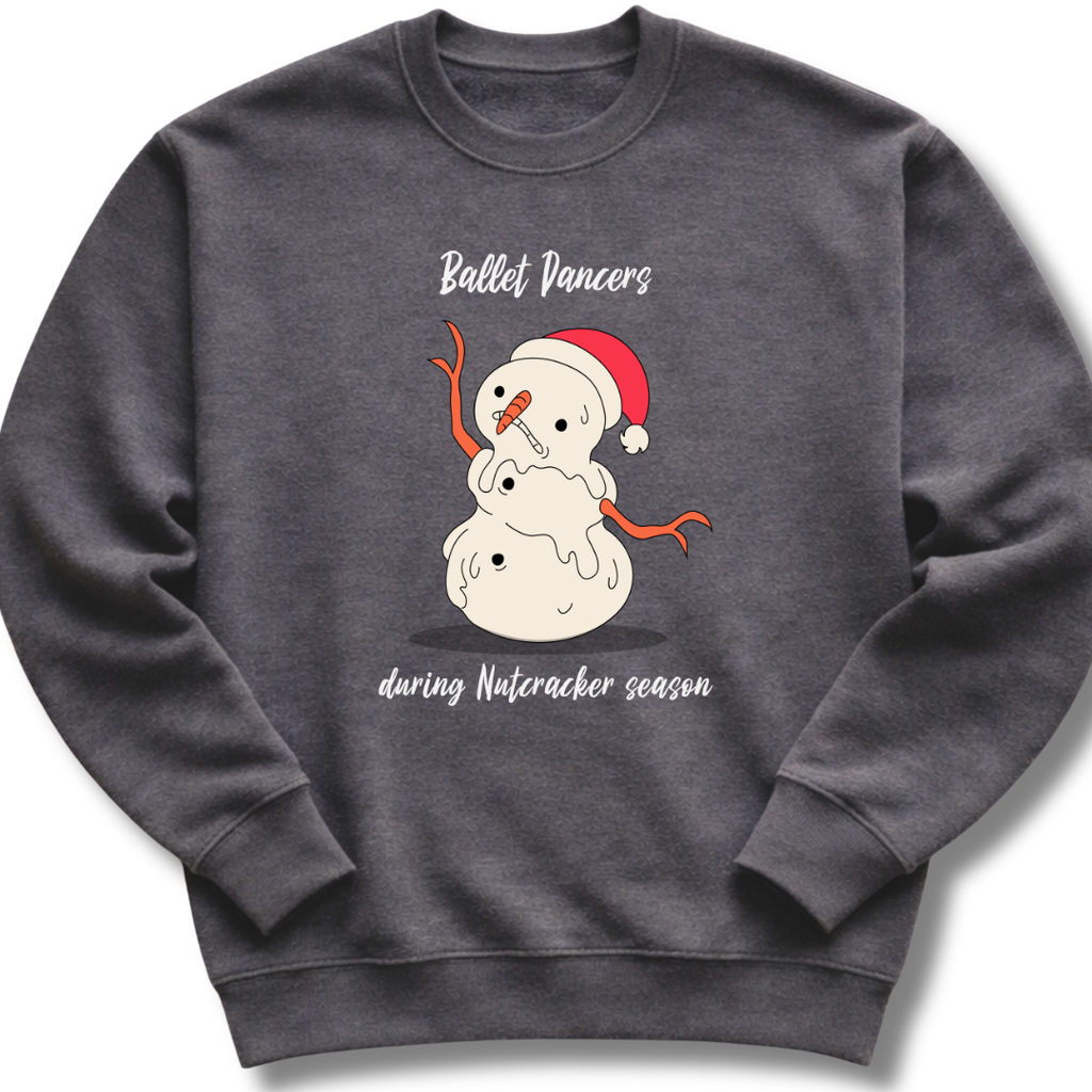 A dark gray crewneck sweatshirt featuring a festive graphic of a snowman wearing a red Santa hat, with the text 'Ballet Dancers' above and 'during Nutcracker season' below.