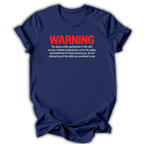 A navy blue short-sleeve t-shirt with a humorous warning printed on the chest. The text reads 'WARNING' in bold red letters, followed by white text explaining that the dance skills shown are performed by a trained professional for safety.