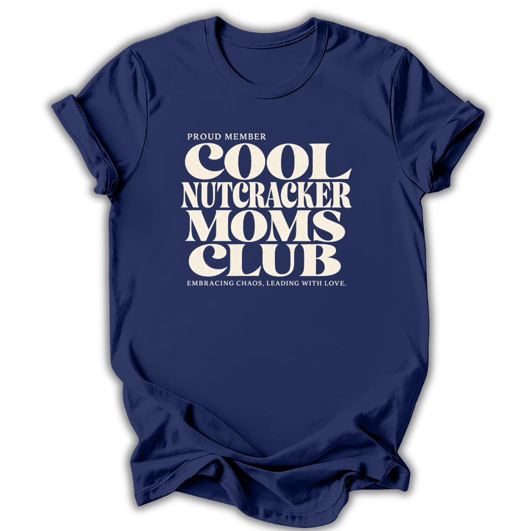 Blue short-sleeve crewneck t-shirt with a cream-colored retro graphic that reads 'PROUD MEMBER COOL NUTCRACKER MOMS CLUB' and 'EMBRACING CHANGE, LEADING WITH LOVE.'.