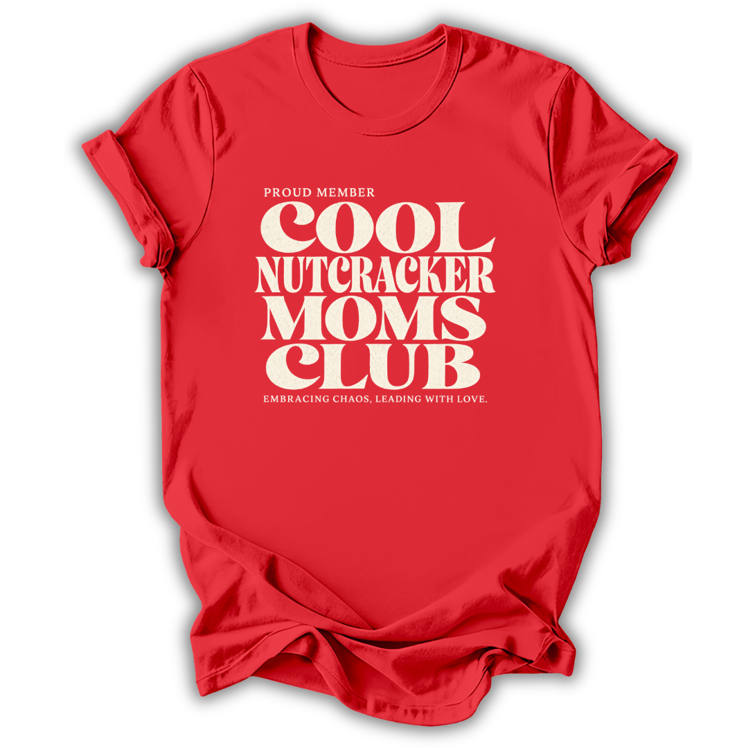 Red short-sleeve crewneck t-shirt with a cream-colored retro graphic that reads 'PROUD MEMBER COOL NUTCRACKER MOMS CLUB' and 'EMBRACING CHANGE, LEADING WITH LOVE.'.