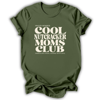 Green short-sleeve crewneck t-shirt with a cream-colored retro graphic that reads 'PROUD MEMBER COOL NUTCRACKER MOMS CLUB' and 'EMBRACING CHANGE, LEADING WITH LOVE.'.