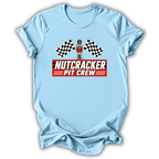 Blue short-sleeve t-shirt with a 'Nutcracker Pit Crew' graphic on the chest, featuring a race flag checkered pattern and a pit crew character, displayed on a clean white background.
