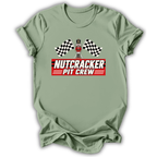 Sage short-sleeve t-shirt with a 'Nutcracker Pit Crew' graphic on the chest, featuring a race flag checkered pattern and a pit crew character, displayed on a clean white background.