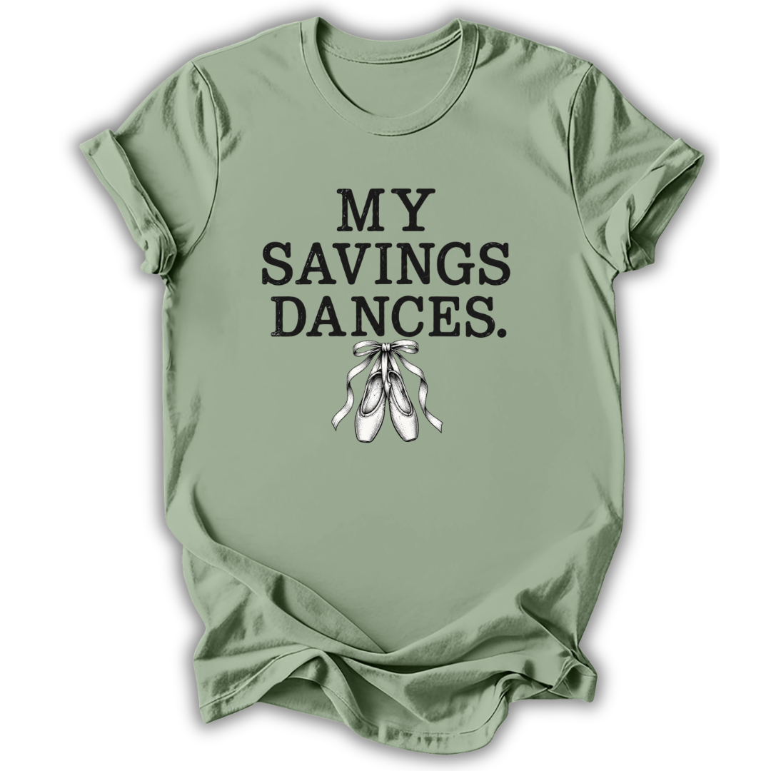 A sage green short-sleeve t-shirt with the text 'MY SAVINGS DANCES.' printed in black, accompanied by a white illustration of ballet pointe shoes, displayed on a clean white background.
