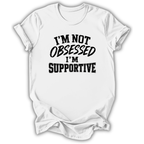 A white short-sleeve crewneck t-shirt with the text 'I'M NOT OBSESSED I'M SUPPORTIVE' printed in black across the chest, shown on a plain white background.