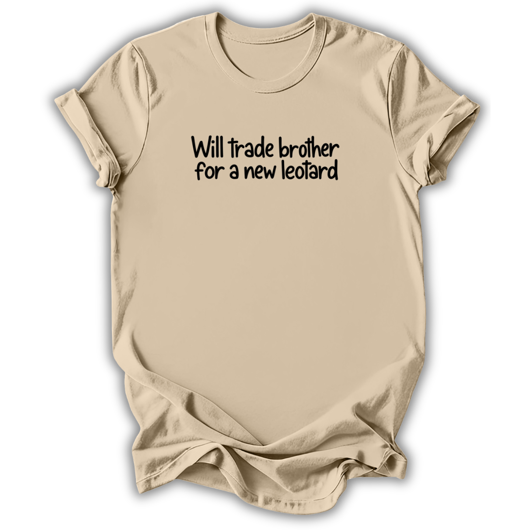 A beige short-sleeve t-shirt with black text on the chest reading 'Will trade brother for a new leotard', displayed against a white background with a soft drop shadow.