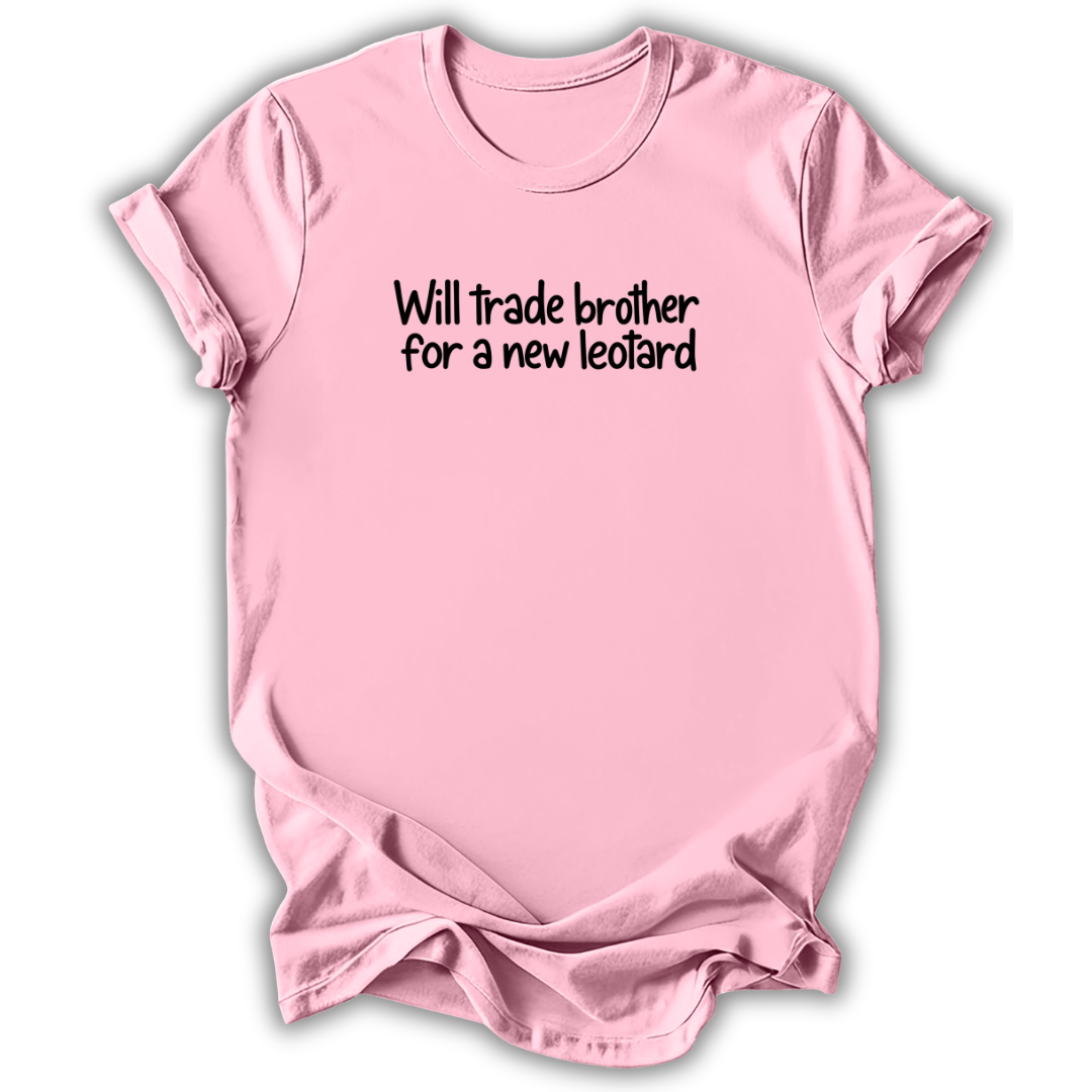 A light pink short-sleeve t-shirt with the text 'Will trade brother for a new leotard' printed in black across the chest, displayed on a clean white background.