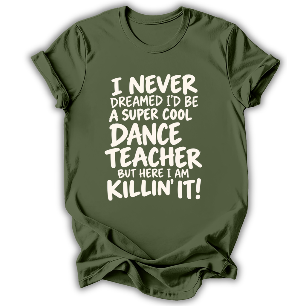 An olive green short-sleeve t-shirt with white text that reads 'I NEVER DREAMED I'D BE A SUPER COOL DANCE TEACHER BUT HERE I AM KILLIN' IT!' displayed on a clean white background.