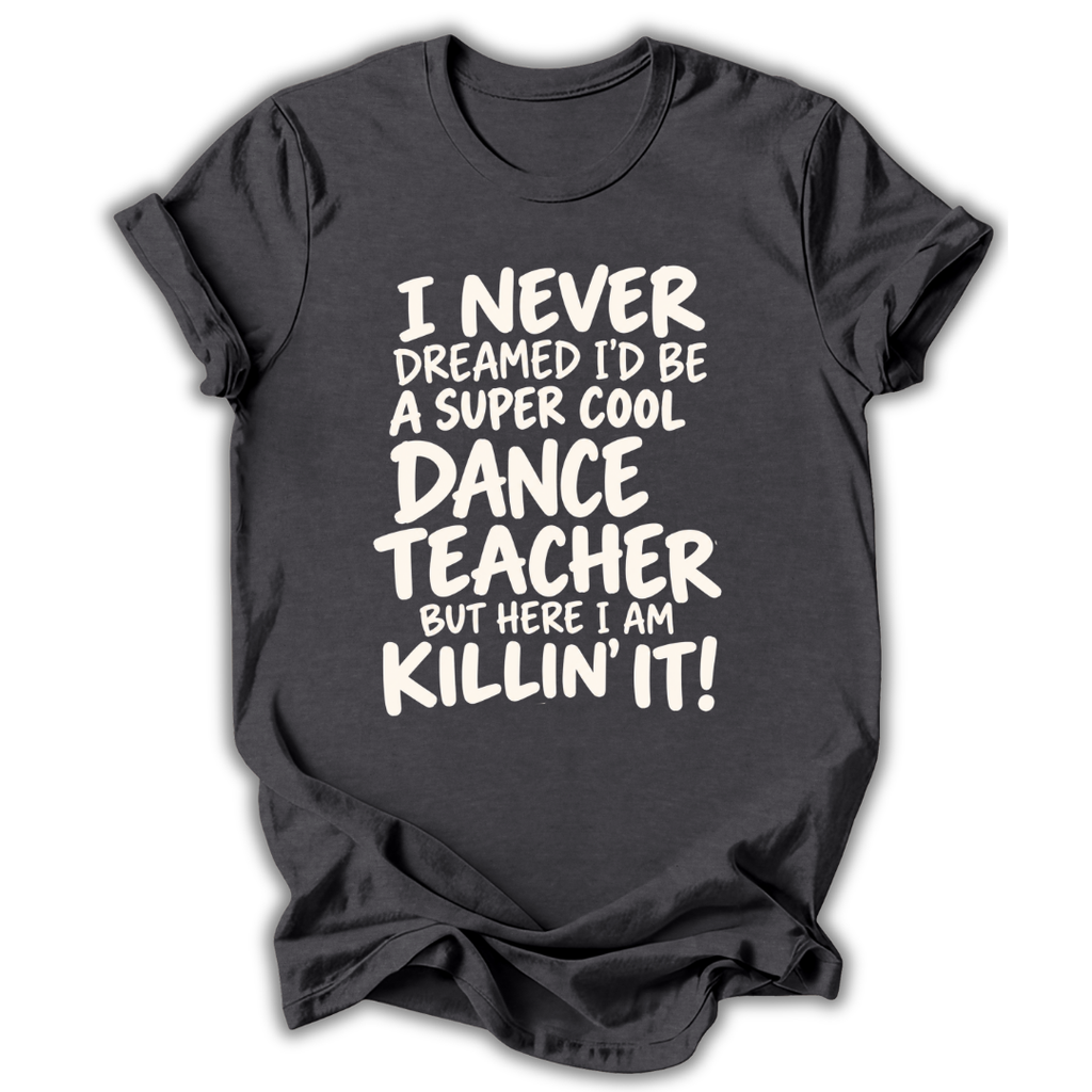 A dark charcoal gray t-shirt with a white graphic text print that reads 'I NEVER DREAMED I'D BE A SUPER COOL DANCE TEACHER BUT HERE I AM KILLIN' IT!' displayed on a clean white background.