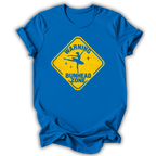 A royal blue short-sleeve t-shirt with a yellow diamond-shaped road sign graphic on the chest that reads 'WARNING BUNHEAD ZONE' with a silhouette of a ballerina.