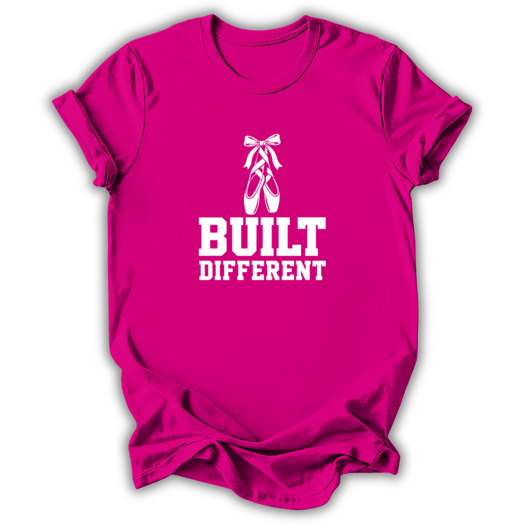 A bright pink short-sleeve t-shirt with a white graphic print featuring ballet slippers and the text 'BUILT DIFFERENT'.