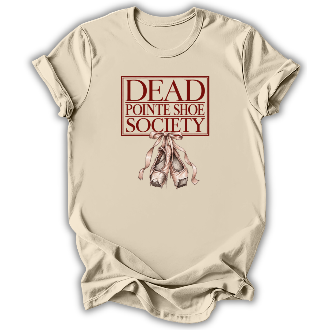 A beige short-sleeve t-shirt with a graphic print reading 'DEAD POINTE SHOE SOCIETY' in dark red letters, featuring an illustration of pinkish-red ballet slippers below, displayed on a white background.