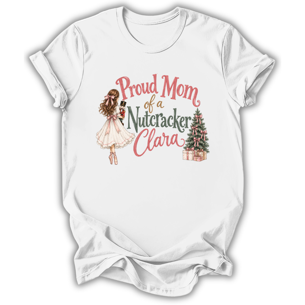 A white short-sleeve crewneck t-shirt with a graphic print on the front. The graphic features a watercolor illustration of a ballerina in a pink tutu holding a nutcracker, next to the text 'Proud Mom of a Nutacker Clara' in pink and dark green lettering, and a small decorated Christmas tree with presents.