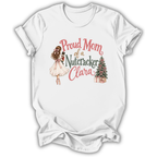 A white short-sleeve crewneck t-shirt with a graphic print on the front. The graphic features a watercolor illustration of a ballerina in a pink tutu holding a nutcracker, next to the text 'Proud Mom of a Nutacker Clara' in pink and dark green lettering, and a small decorated Christmas tree with presents.
