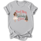 A light gray short-sleeve t-shirt with a graphic print on the front. The graphic features a vintage-style illustration of a woman in a white dress holding a nutcracker, next to the text 'Proud Mom of a Nutcracker Clara' in pink and green lettering, and a small decorated Christmas tree with wrapped gifts.