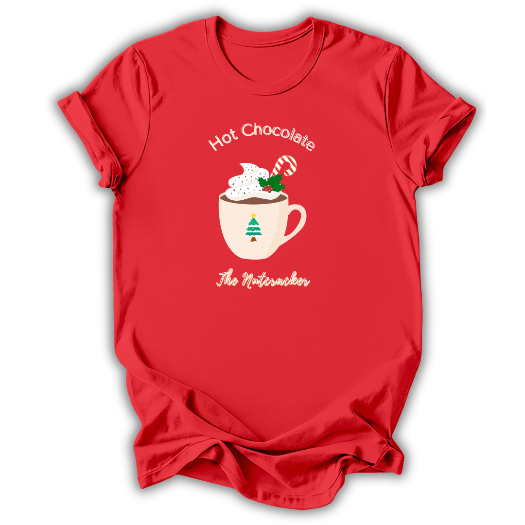 A red short-sleeve t-shirt with a holiday graphic on the front. The graphic features a white mug filled with hot chocolate, topped with whipped cream, a candy cane, and a green Christmas tree, with the text 'Hot Chocolate' above and 'The Nutacker' below.