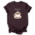 A dark brown short-sleeve t-shirt with a graphic of a white coffee cup on a saucer, surrounded by coffee beans and steam, with the text 'The Nutcracker' above and 'Coffee' below.