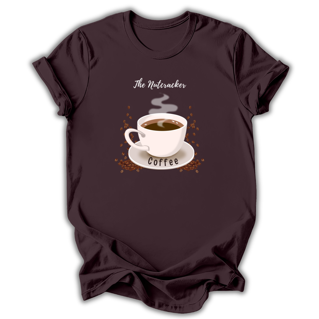 A dark brown short-sleeve t-shirt with a graphic of a white coffee cup on a saucer, surrounded by coffee beans and steam, with the text 'The Nutcracker' above and 'Coffee' below.