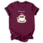 A maroon short-sleeve t-shirt with a graphic print of a steaming coffee cup on a saucer, surrounded by coffee beans, with the text 'The Nutcracker' above and 'Coffee' below, displayed on a white background.