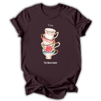 A dark brown short-sleeve t-shirt with a graphic of a stack of four colorful teacups and the text 'Tea' and 'The Nutcracker' printed on the front, shown against a plain white background.