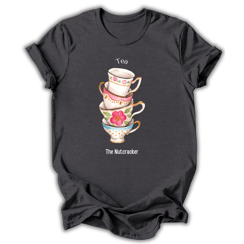 A dark charcoal gray short-sleeve t-shirt with a graphic of a stack of four floral teacups. The top cup is white with pink flowers and the word 'Tea' above it, the next is pink with gold trim, the next is light blue with a pink flower, and the bottom cup is white with gold trim and the text 'The Nutcracker' below.