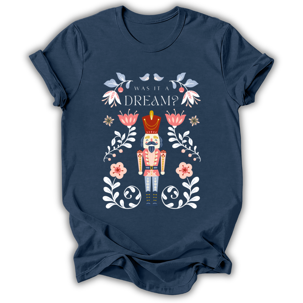 A navy blue short-sleeve t-shirt with a colorful graphic of a nutcracker surrounded by flowers and the text 'WAS IT A DREAM?' on the front, displayed against a solid white background.