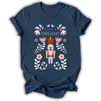 A navy blue short-sleeve t-shirt with a colorful graphic of a nutcracker surrounded by flowers and the text 'WAS IT A DREAM?' on the front, displayed against a solid white background.