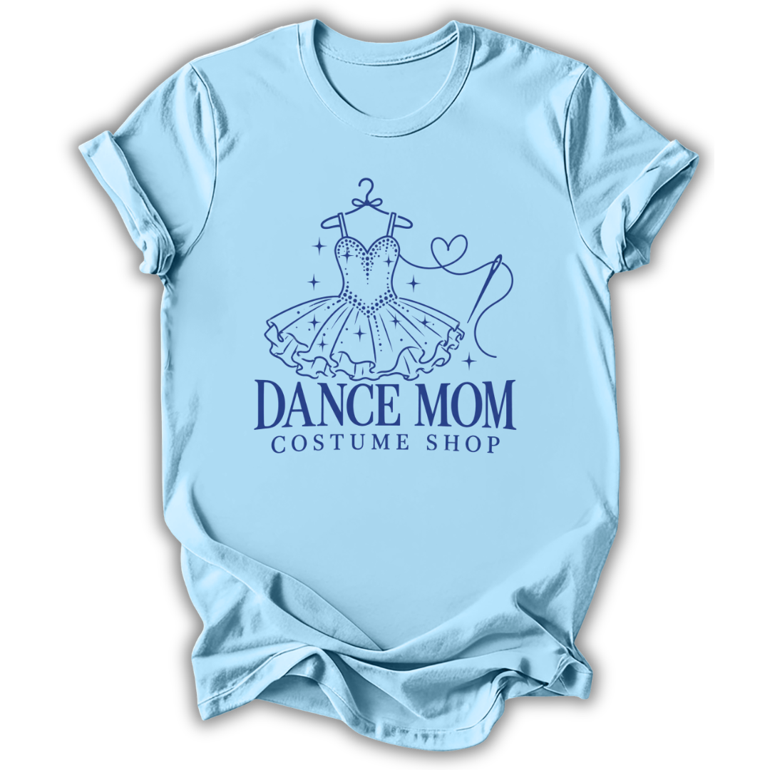 A light blue short-sleeve t-shirt with a dark blue graphic of a ballroom dance dress on a hanger, stars, a heart, and the text 'DANCE MOM COSTUME SHOP'.
