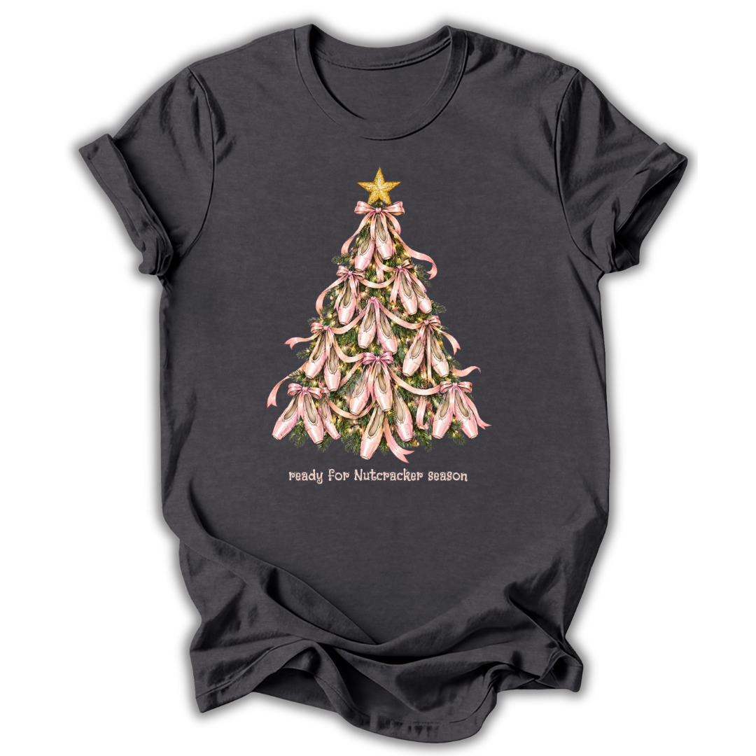 A dark charcoal gray t-shirt with a graphic of a Christmas tree made of pink orchids, topped with a gold star and the text 'ready for Nutcracker season' printed below.