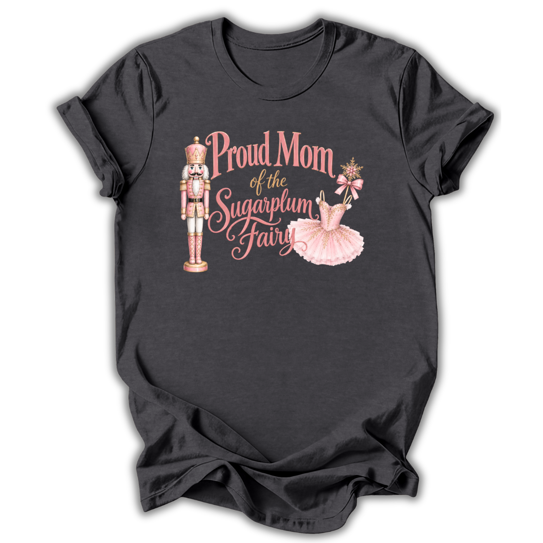 A dark charcoal gray short-sleeve t-shirt with a graphic print on the front. The graphic features a pink nutcracker, a pink tutu, and the text 'Proud Mom of the Sugarplum Fairy' in pink and gold lettering, displayed against a clean white background.