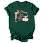 A dark green short-sleeve t-shirt with a graphic on the front featuring a nutcracker, a pink tutu, and the text 'Proud Grandma of the Sugarplum Fairy' in pink script.