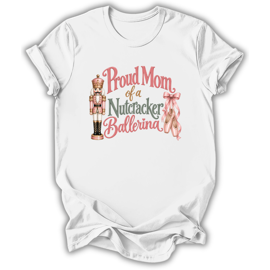 A white short-sleeve crewneck t-shirt with a graphic print that reads 'Proud Mom of a Nutcracker Ballerina' in pink and green lettering, accompanied by an illustration of a nutcracker and a pink ribbon.