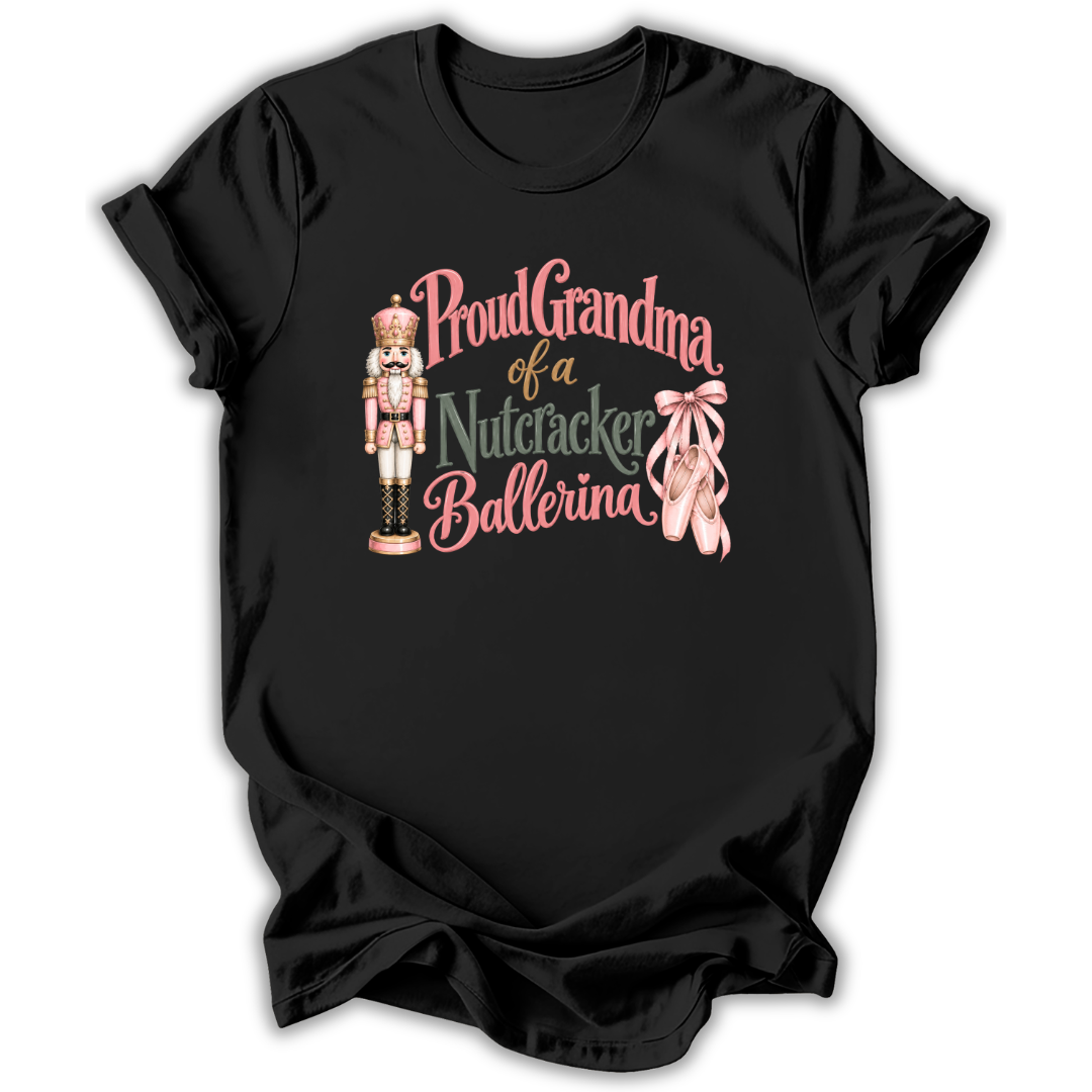 A black short-sleeve t-shirt with a graphic print that reads 'Proud Grandma of a Nutcracker Ballerina' in pink and green lettering, accompanied by an illustration of a nutcracker and pink ballet slippers.