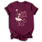 A maroon short-sleeve t-shirt with a graphic print of a ballerina in a pink tutu and rose, featuring the text 'Waltz of the Flowers' and 'The Night Before' on a white background.