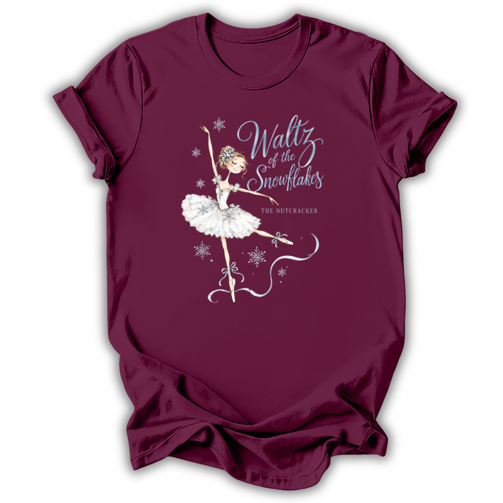A maroon short-sleeve t-shirt featuring a white graphic of a ballet dancer with the text 'Waltz of the Snowflakes' and 'The Nutcracker' on the front, displayed against a white background.