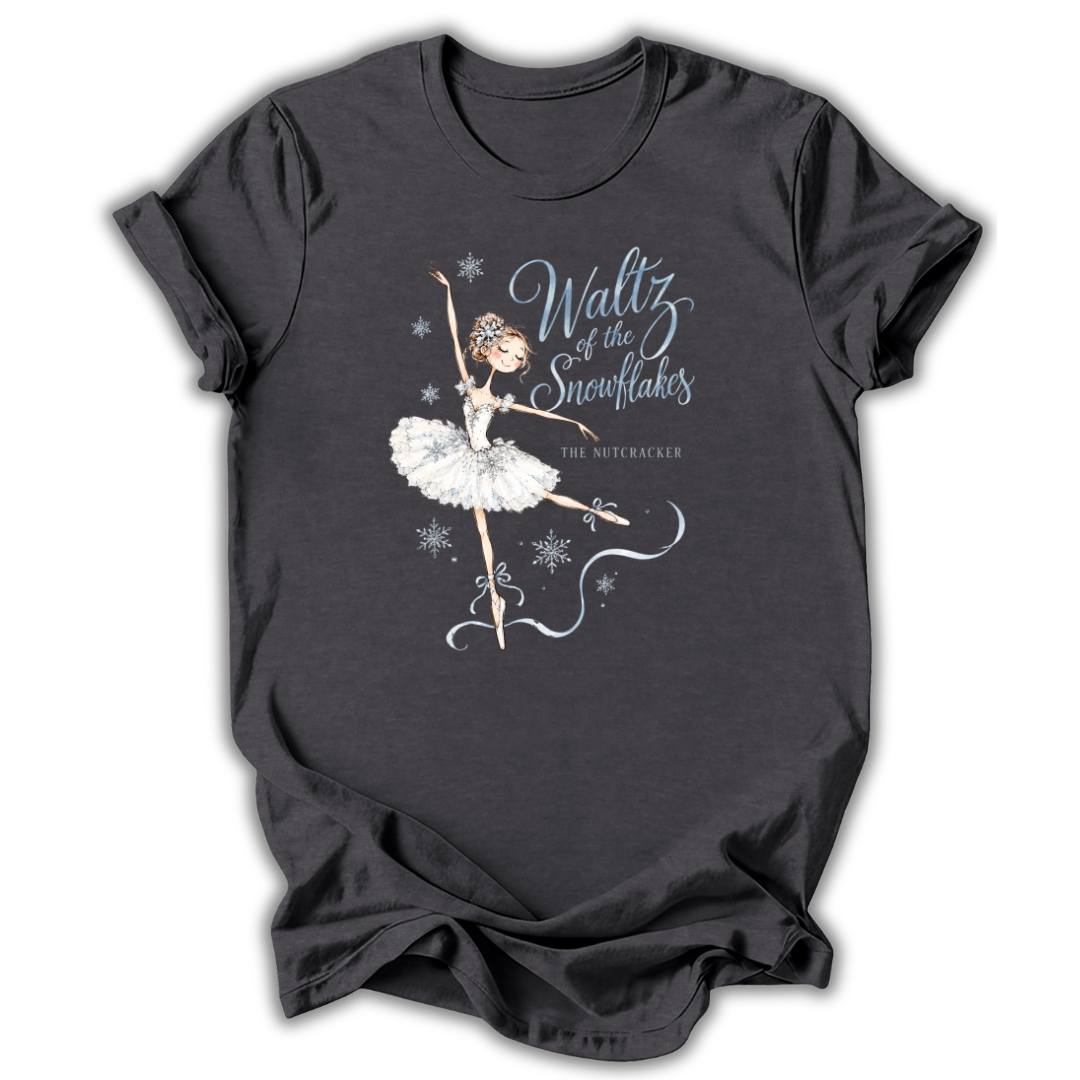 A dark charcoal gray t-shirt featuring a graphic of a ballerina in a white tutu with the text 'Waltz of the Snowflakes' and 'The Nutcracker' printed on the front, displayed against a plain white background.