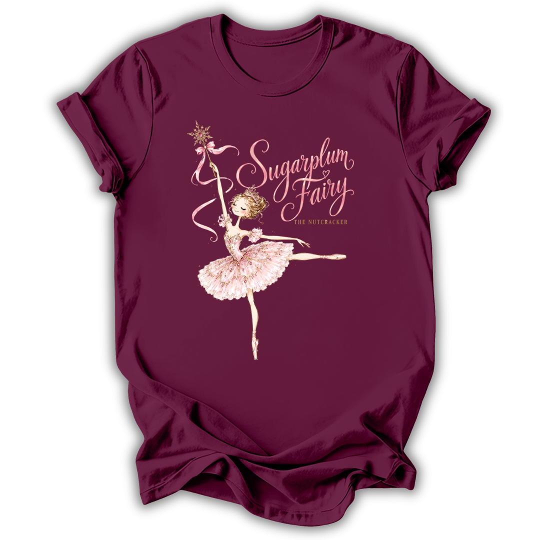 A maroon short-sleeve t-shirt with a graphic of a ballerina and the text 'Sugarplum Fairy' and 'The Asteroid' printed on the front, displayed against a white background.