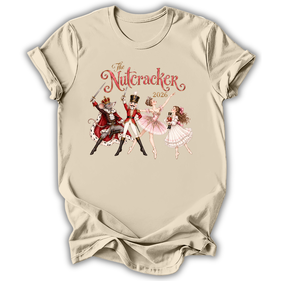 A beige short-sleeve t-shirt with a vintage-style graphic of 'The Nutcracker' characters (a nutcracker, a ballerina, and a fairy) and the title 'The Nutcracker 2026' printed on the chest