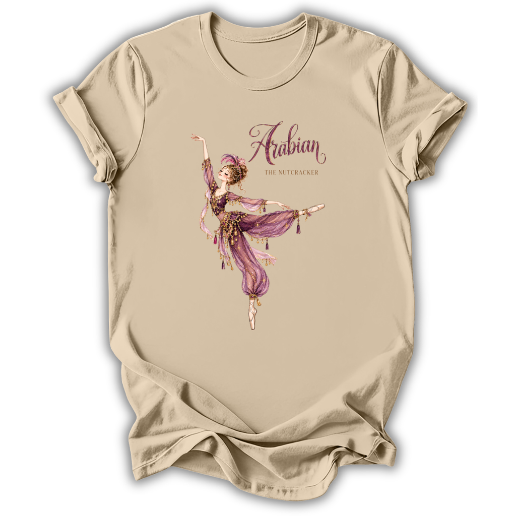 A beige short-sleeve t-shirt with a graphic print of an Arabian dancer in a purple outfit and the text 'Arabian The Nutcracker' on the front, displayed against a white background.