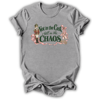 A heather gray short-sleeve t-shirt with a graphic print on the front. The graphic features a nutcracker soldier, pink ribbons, and the text 'Not in the Cast Still in the CHAOS' in dark green and pink lettering.