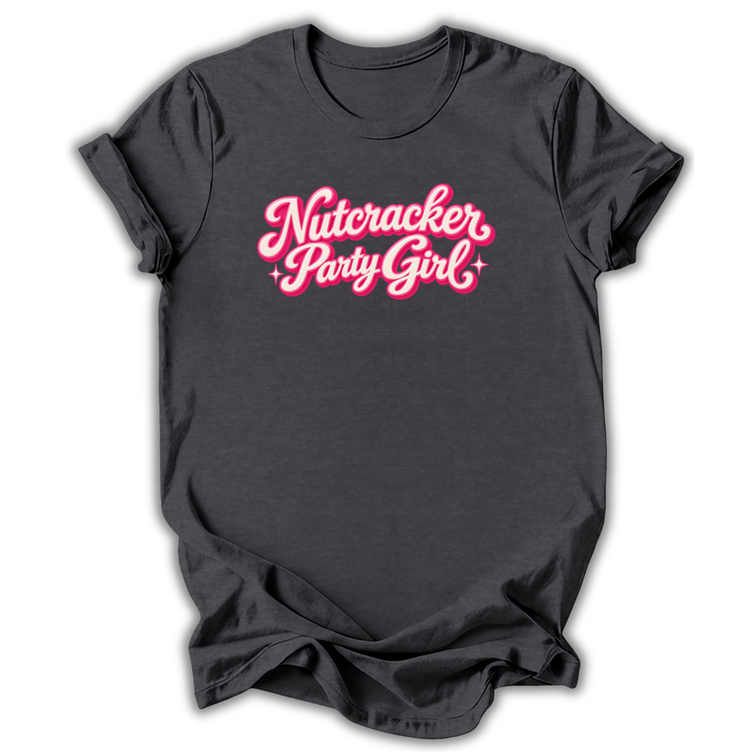 A dark charcoal gray t-shirt with 'Nutcracker Party Girl' printed in a pink cursive font with a white outline across the chest, displayed on a clean white background.