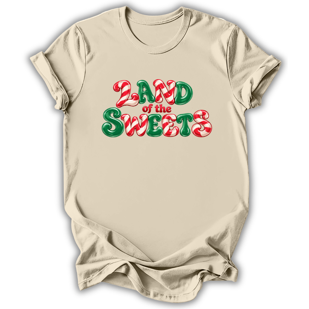 A beige short-sleeve t-shirt with a 'LAND of the SWEETS' graphic printed on the chest in red and green candy cane and peppermint font, displayed on a clean white background.