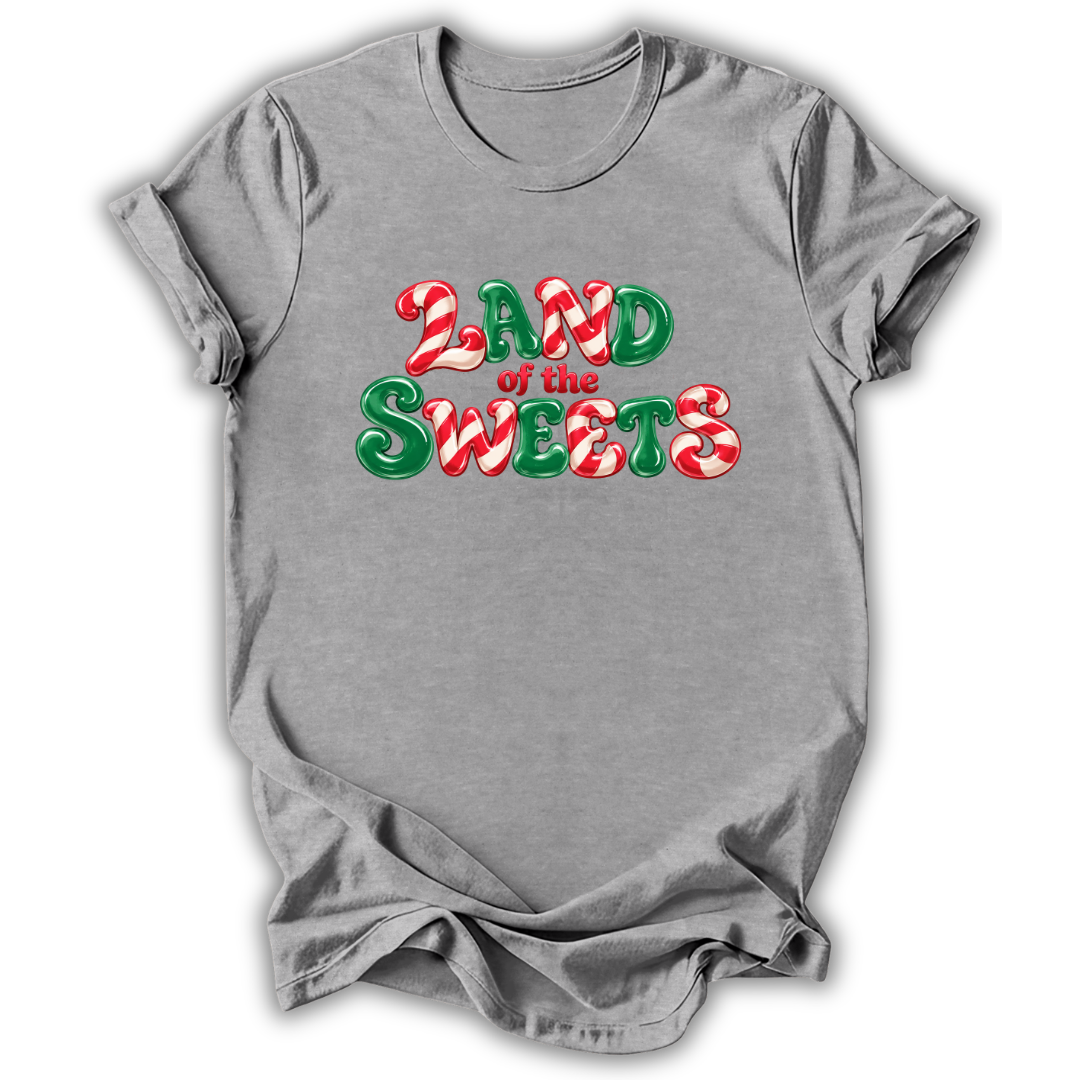 Gray short-sleeve crewneck t-shirt with a festive graphic reading 'LAND of the SWEETS' in red and green candy cane patterns, displayed on a clean white background.