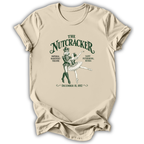 A beige short-sleeve t-shirt with a vintage-style green graphic of 'The Nutcracker' ballet dancers and text detailing the premiere in Saint Petersburg, Russia, shown on a white background.