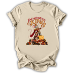 A beige short-sleeve t-shirt with a graphic print of a mouse dressed as a king on a pile of gold coins, with the text 'I just can't wait to be KING'.