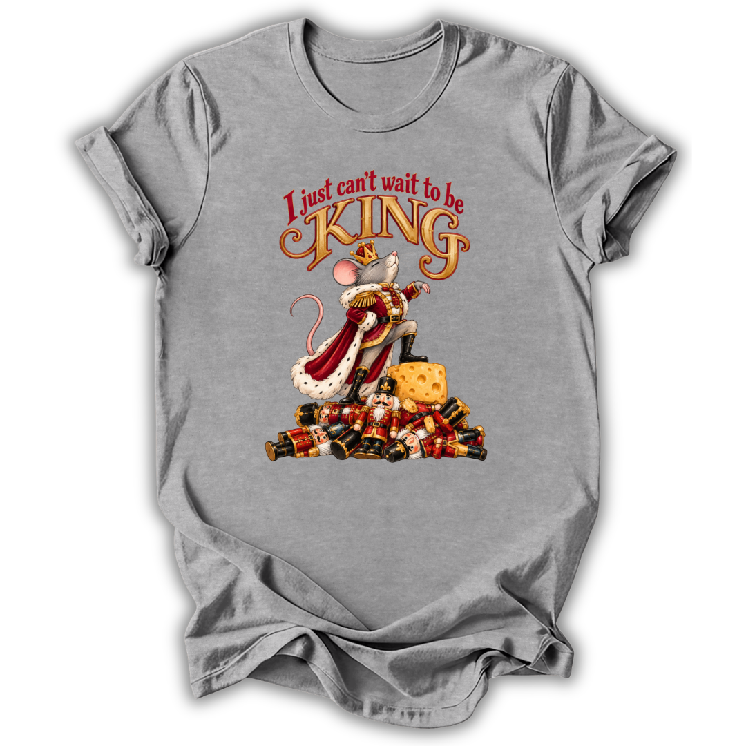 A heather gray short-sleeve t-shirt with a graphic print of a mouse dressed as a king on a pile of gold coins, with the text 'I just can't wait to be KING' above it.
