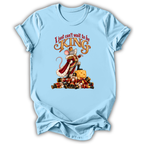 A light blue short-sleeve t-shirt with a graphic of a mouse dressed as a king on a pile of gold coins, with the text 'I just can't wait to be KING' above it.