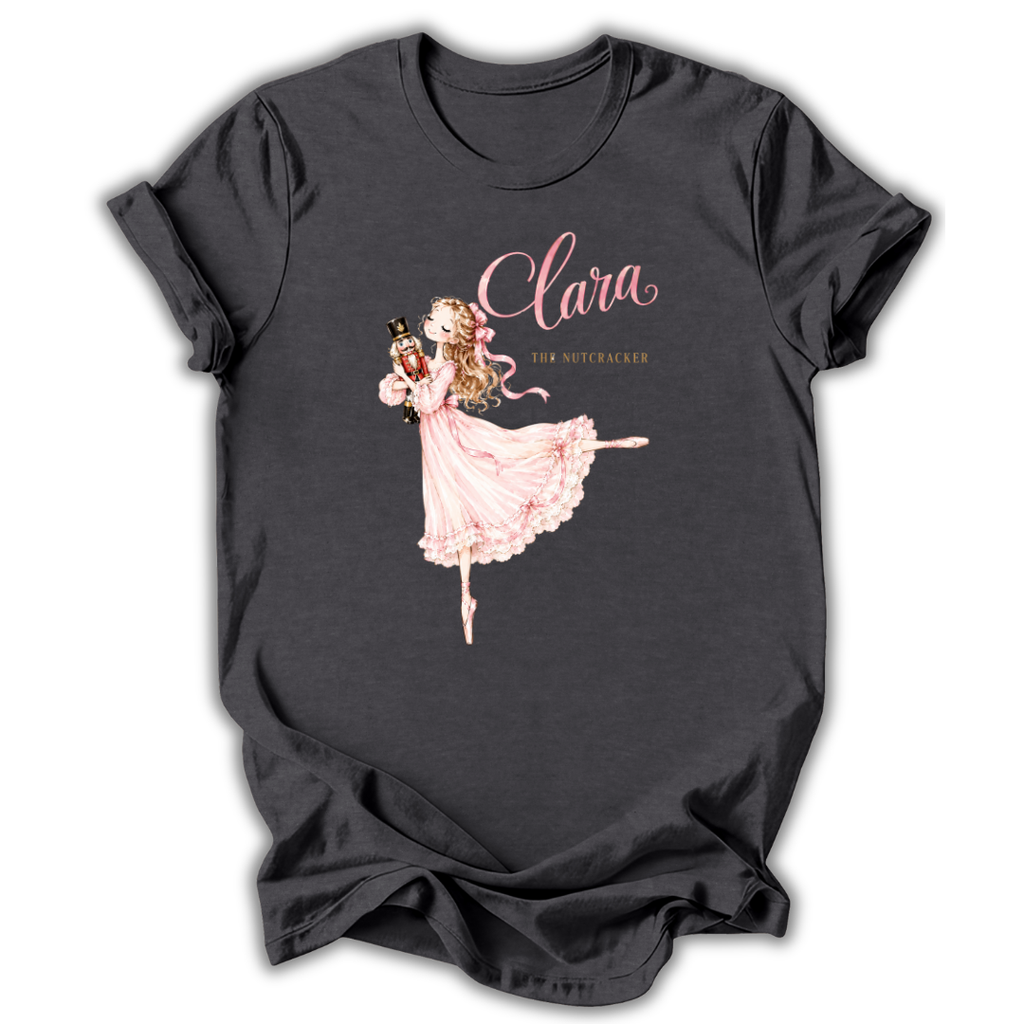 A dark charcoal gray t-shirt featuring a graphic of a ballerina in a pink dress holding a nutcracker, with the text 'Clara' and 'The Nutcracker' printed on the front.
